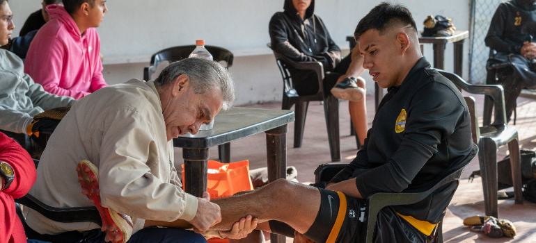 A UAE football coach massaging a player's leg.