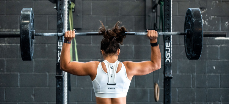 A woman trained by personal trainers sharjah lifting weights