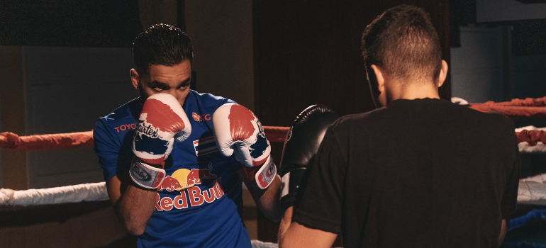A man and male personal trainer ajman sparring with one another