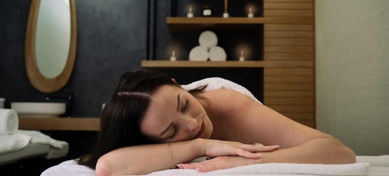 A woman lying in the SPA center and thinking about ways to maintain fitness levels while traveling in UAE.