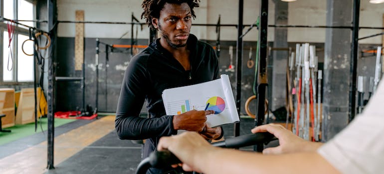 dedicated trainer talking to his client about his workout plan