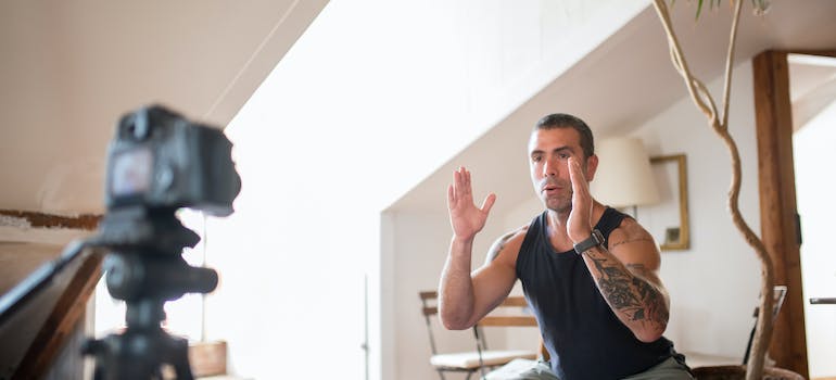 Online personal trainer in Dubai in front of a camera explaining an exercise