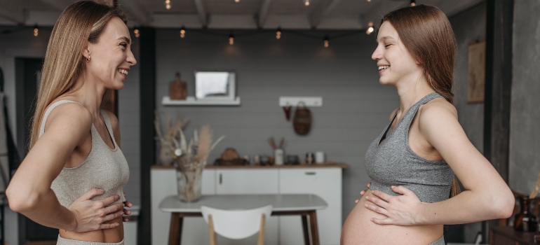 pregnant woman talking to an experienced trainer showing how important it is to pick the right personal trainer in the UAE