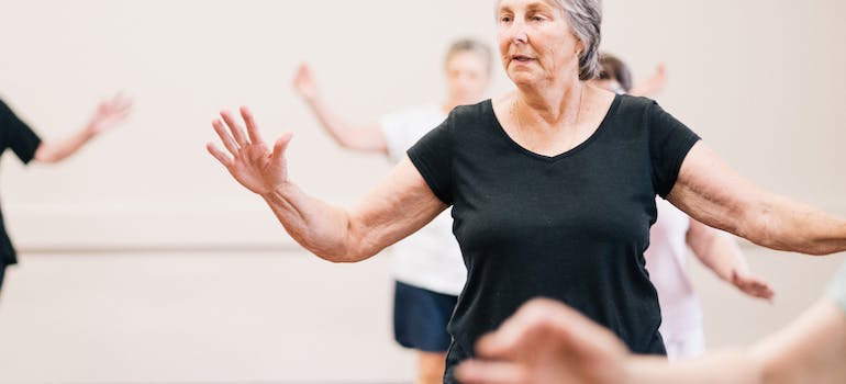 older woman doing a dance exercise in Sharjah