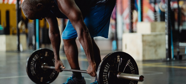 A person lifting weights and enjoying UAE's Wellness Tourism Industry.
