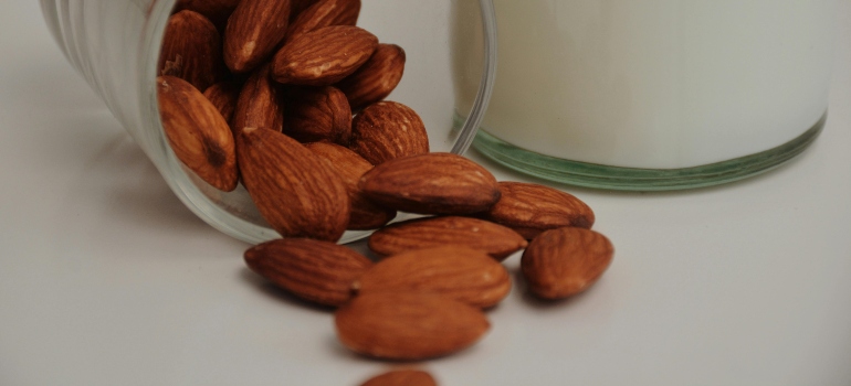 Almond next to a glass of almond milk.