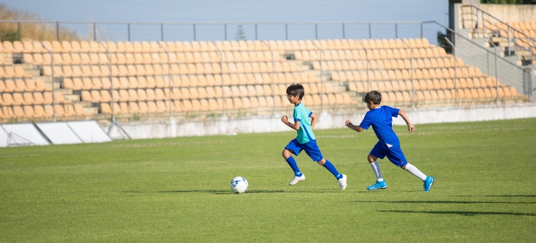 Kids playing football, like you who is learning how to improve your football skills in Ras Al Khaimah.
