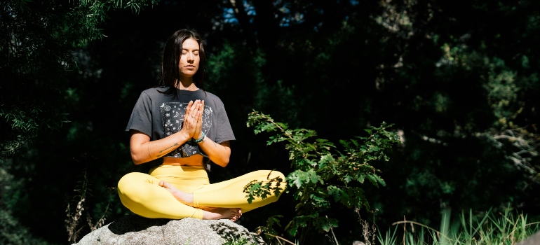 A woman doing yoga after deciding between morning vs. evening yoga.