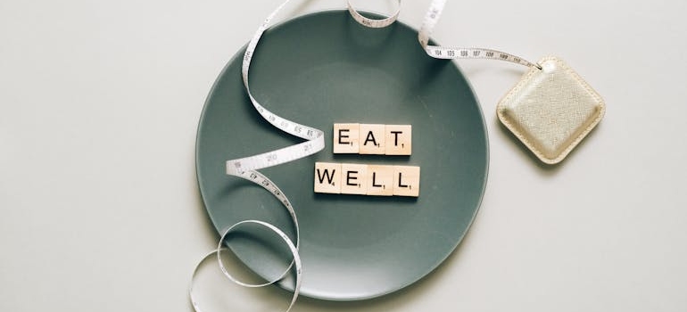 a plate that says eat well on it symbolizing Tracking Food Intake In Weight Loss