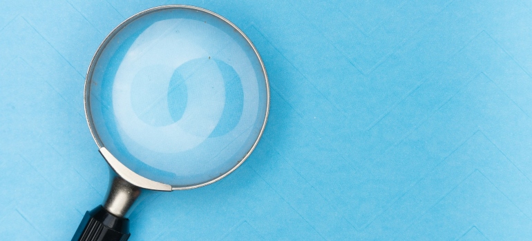 A magnifying glass on a blue surface