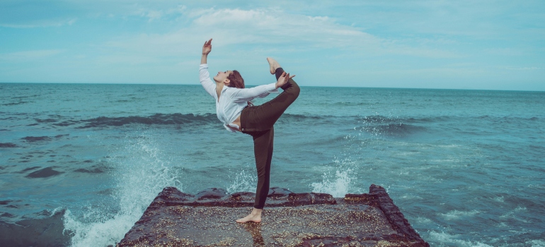 girl doing yoga by the sea