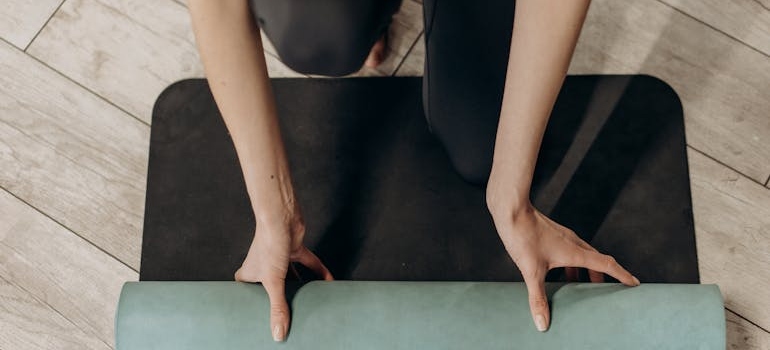 a person rolling out a yoga mat