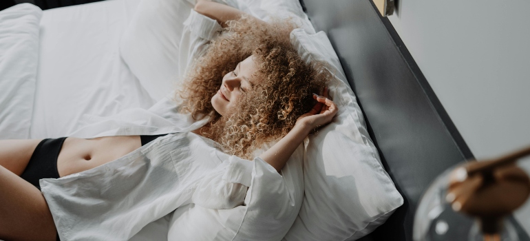 Woman in White Dress Lying on Bed happy because she is Starting a Healthier Lifestyle in the UAE