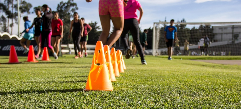 Teens doing cone drills during group fitness training; personal training boosts confidence in teens in Dubai.