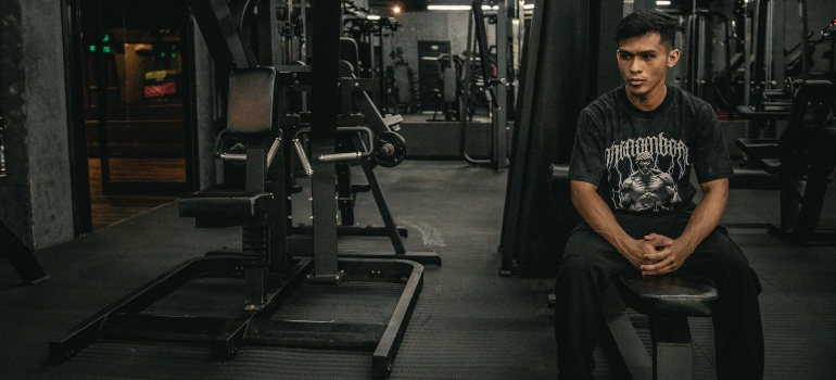 Person sitting in a gym and thinking about the weight loss mistakes to avoid In Dubai
