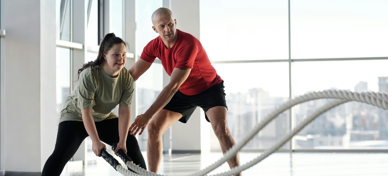 Mother training with a personalized fitness trainer, making the most of her free time as a parent.
