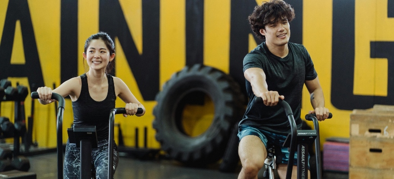 A couple using elliptical trainers as part of low-impact cardio workouts for joint health in Abu Dhabi.