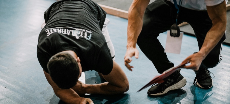 a trainer and a sportsman lying on the floor