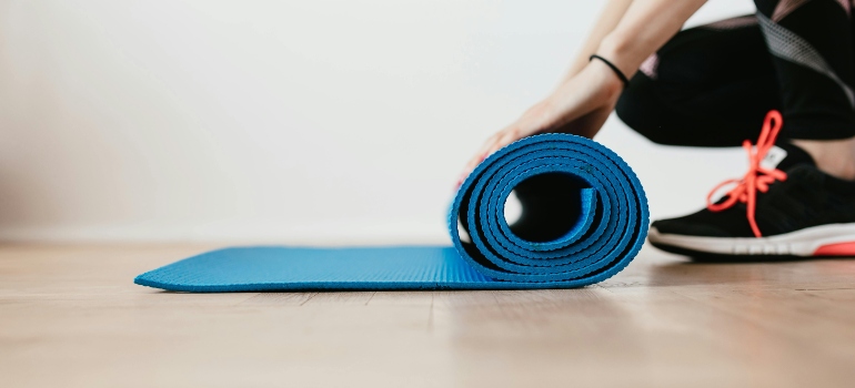 Close-up of rolled blue yoga mat symbolizing Gentle Fitness That Helps Your Body Recover Safely and daily self-care.
