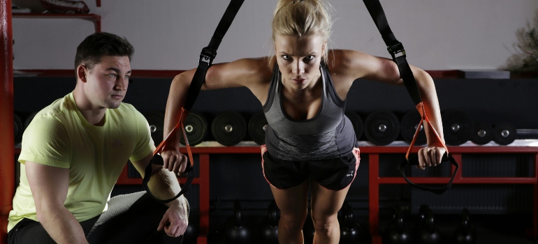 A woman is working out with a personal trainer in Dubai.