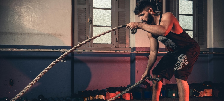 A man working out with a rope, thinking about "Is it possible to transform your body in 3 months?"
