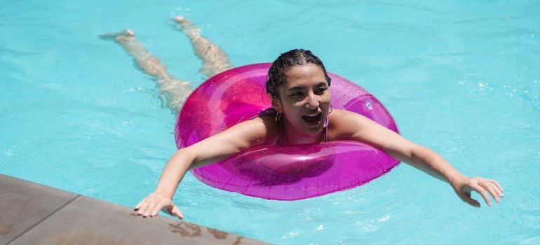 a girl with a rubber swimming ring learning to swim