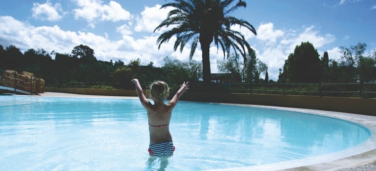 A kid jumping into a pool