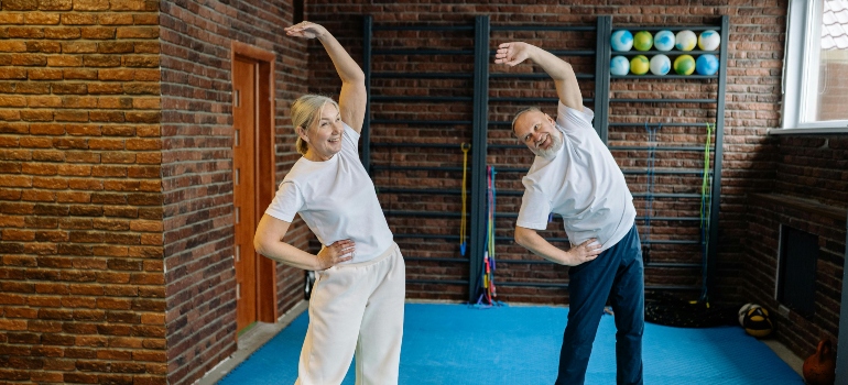 An older couple doing stretches.